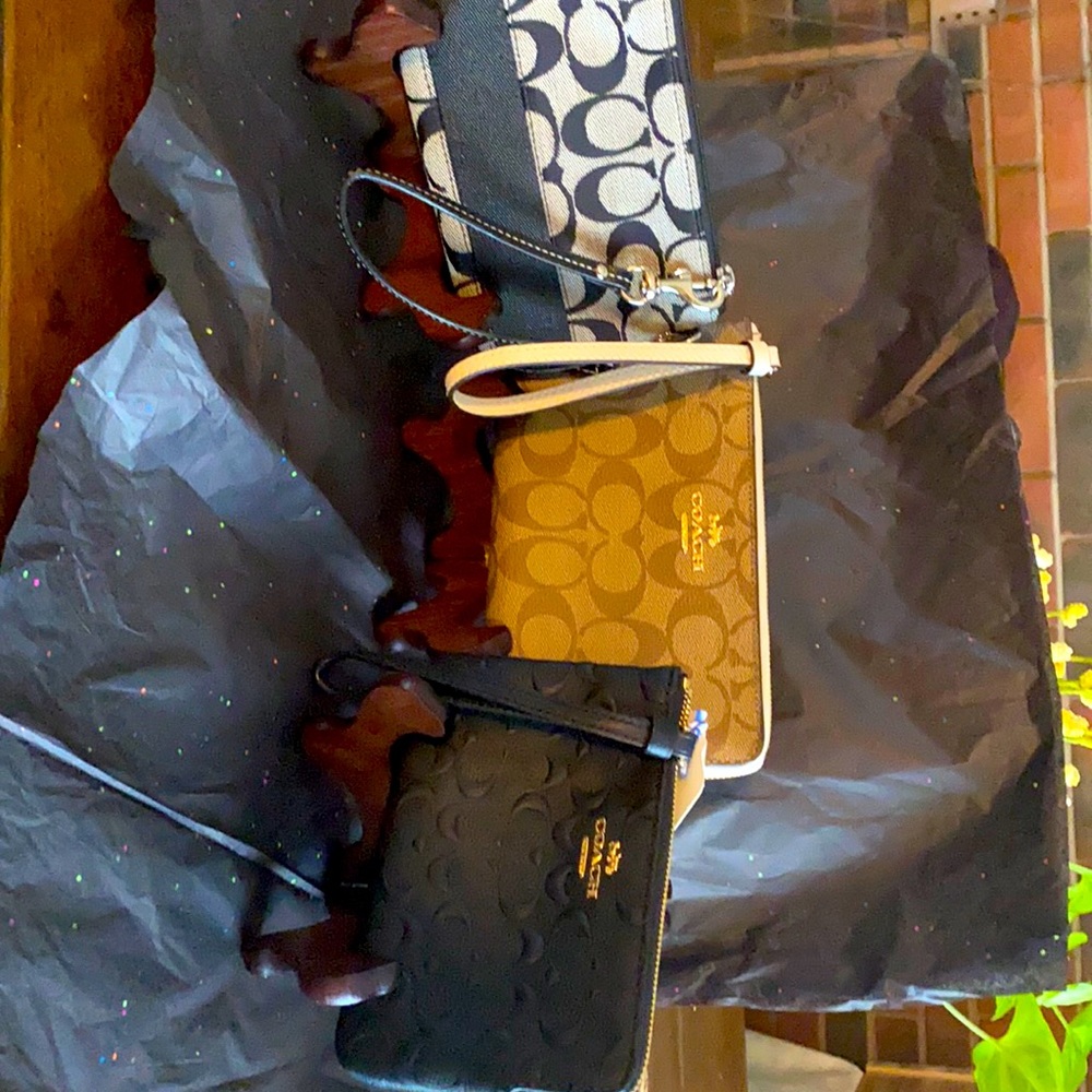 Three authentic coach wristlets the tan ones a little larger than the two black